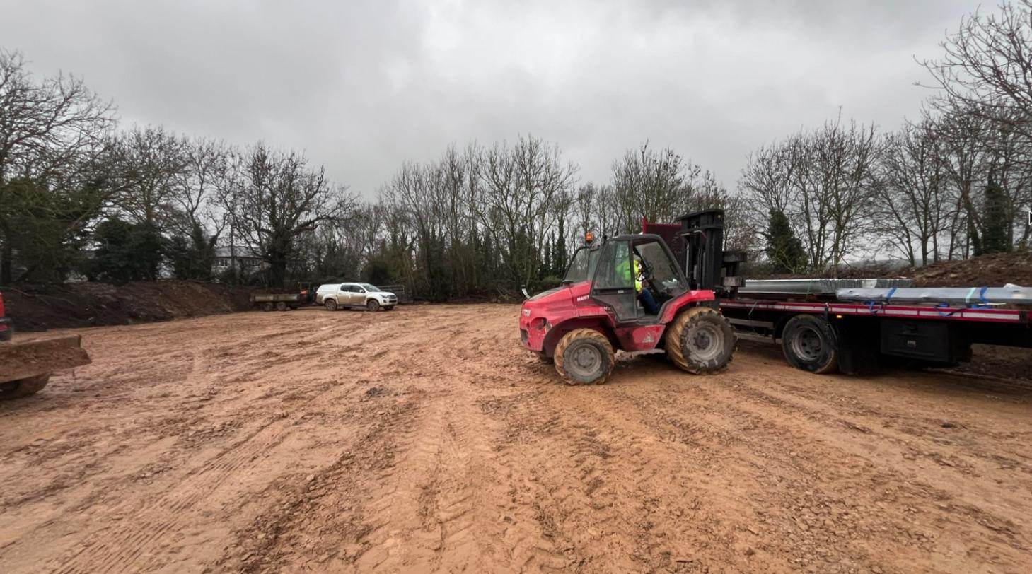 Groundworks with a telehandler unloading fencing